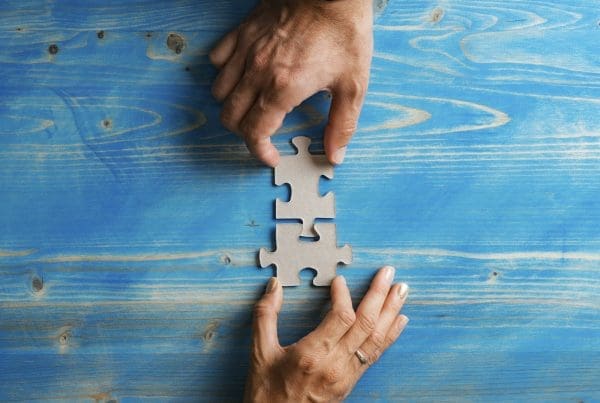 Business partners matching two puzzle pieces in a conceptual image of a merger